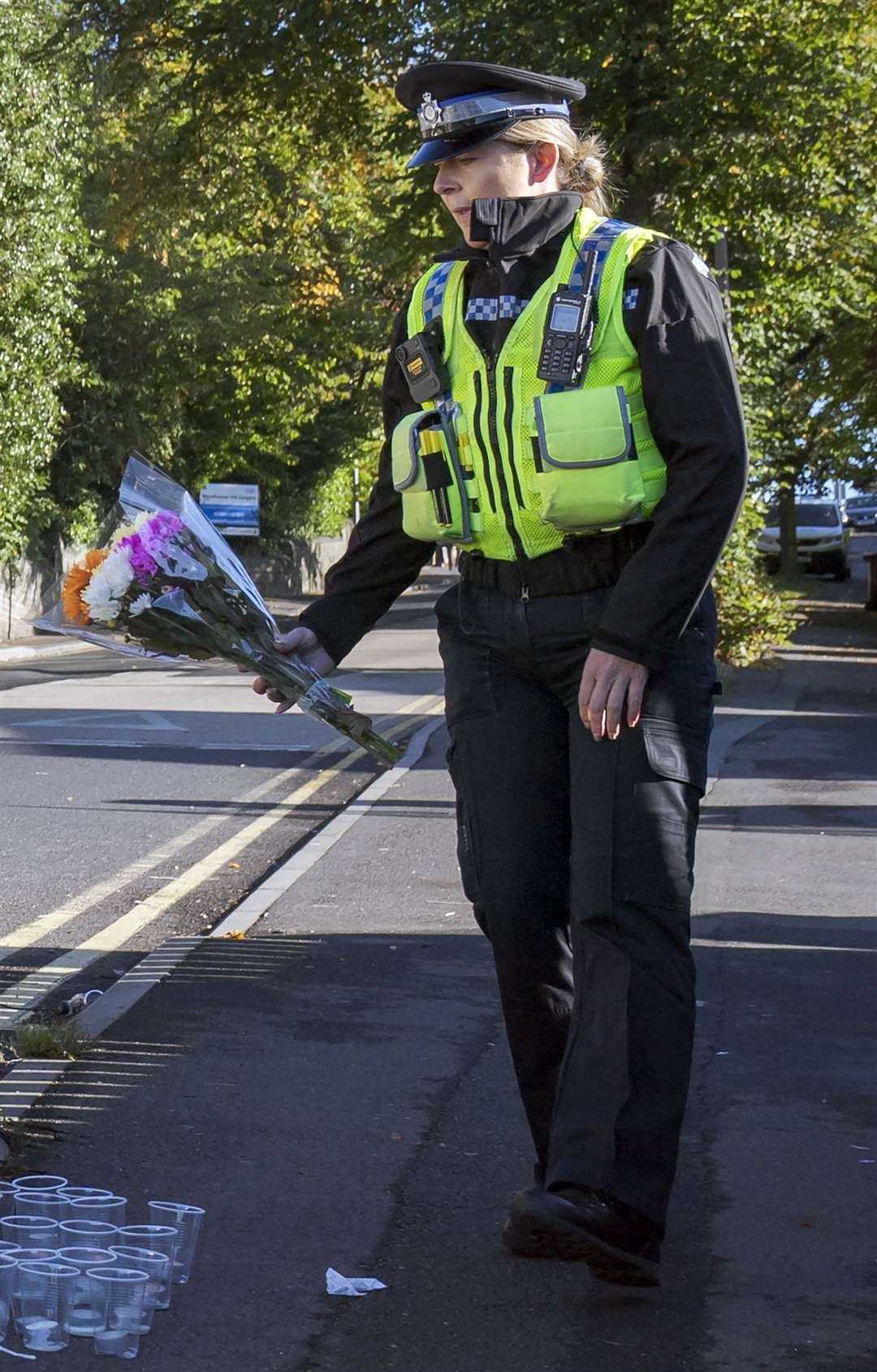 A police community support officer lays a floral tribute at the scene (Danny Lawson/PA)