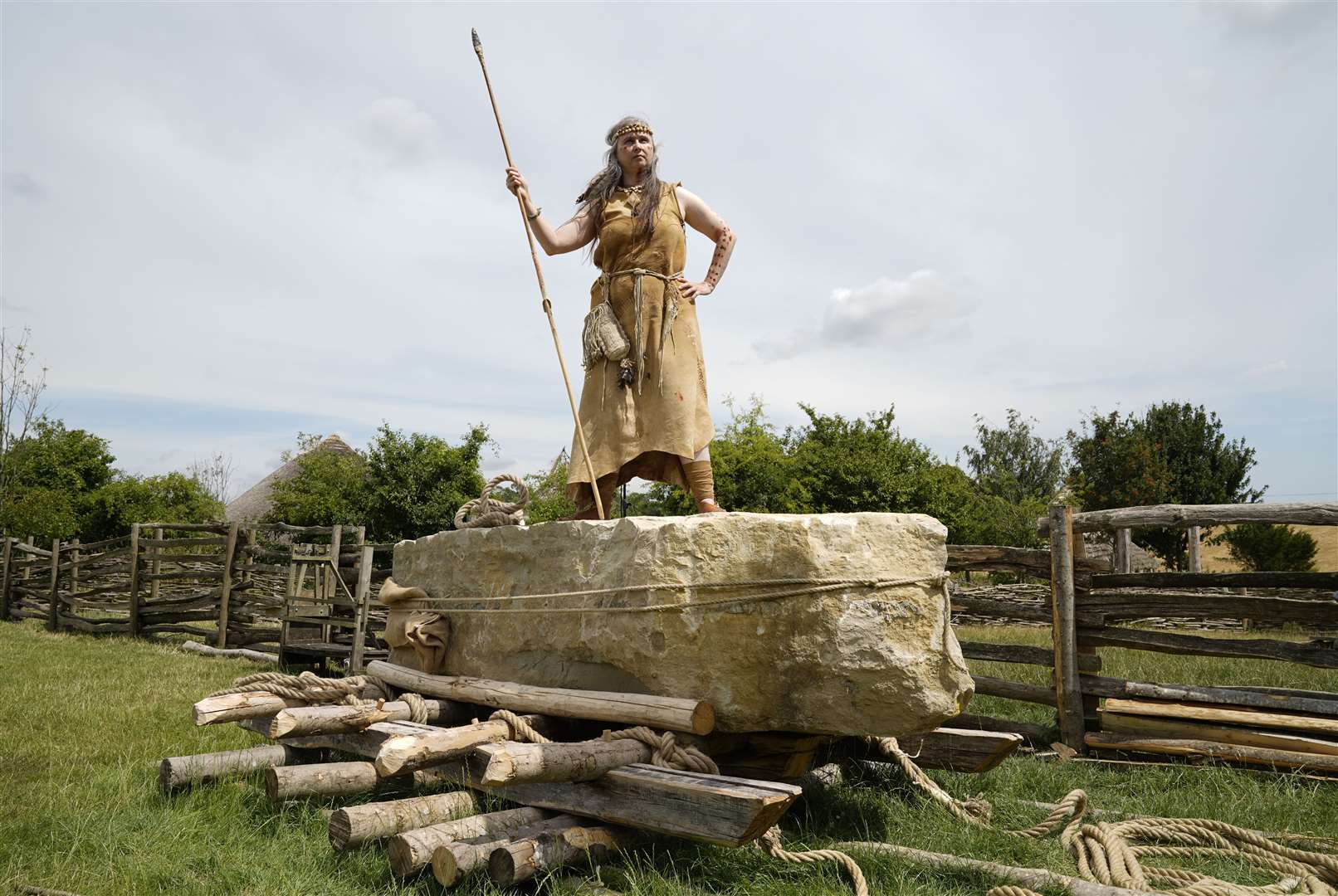 Jo Shorter, a Stone Age enthusiast and volunteer at Butser ancient farm, poses for a photograph on the stone (Andrew Matthews/PA)