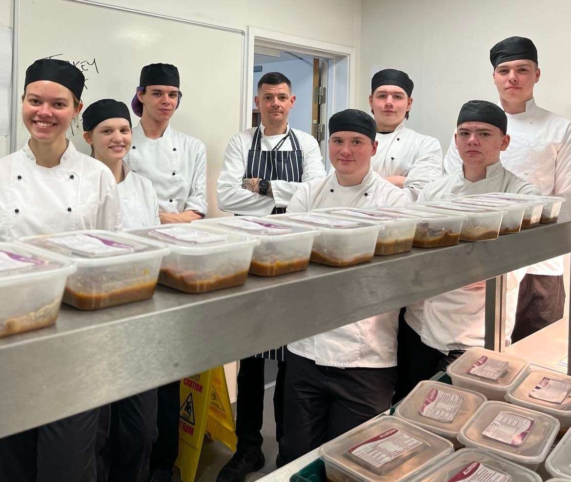 Tetiana Potapko, Jacob Cameron, Taylor Robertson, Matthew Urquhart, Jack Mackenzie, Josh Henderson, Kristoffer Cartwright and Logan Ross with the first batch of meals they cooked for Food for Families.