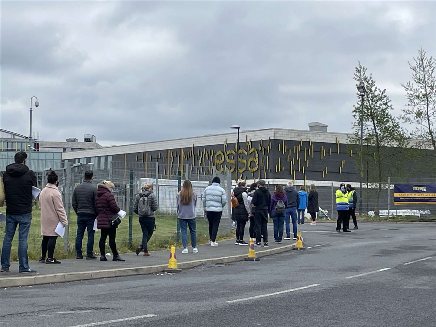 People queue for the vaccination centre at the Essa Academy in Bolton (PA)