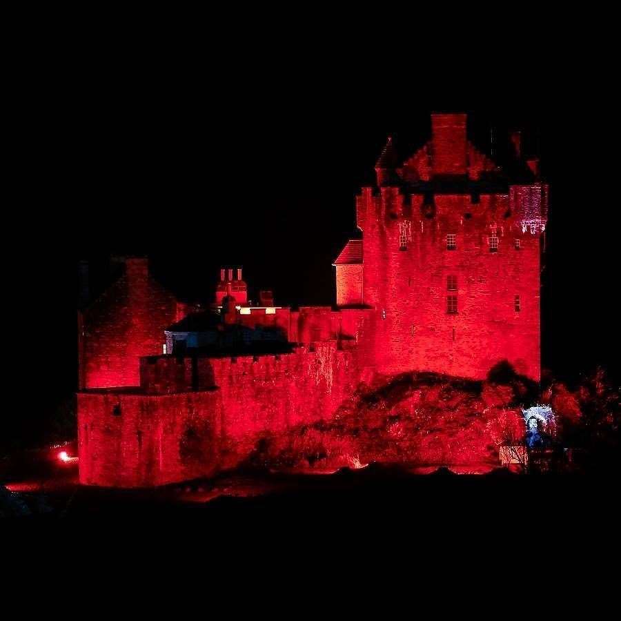 Eilean Donan castle lit up red.