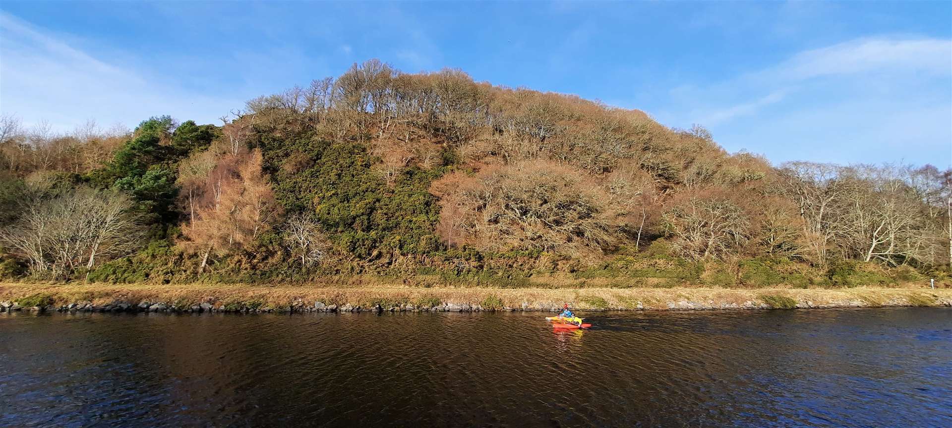 A couple of kayakers enjoy a fine morning on the Caledonian Canal in front of the former Torvean quarry.