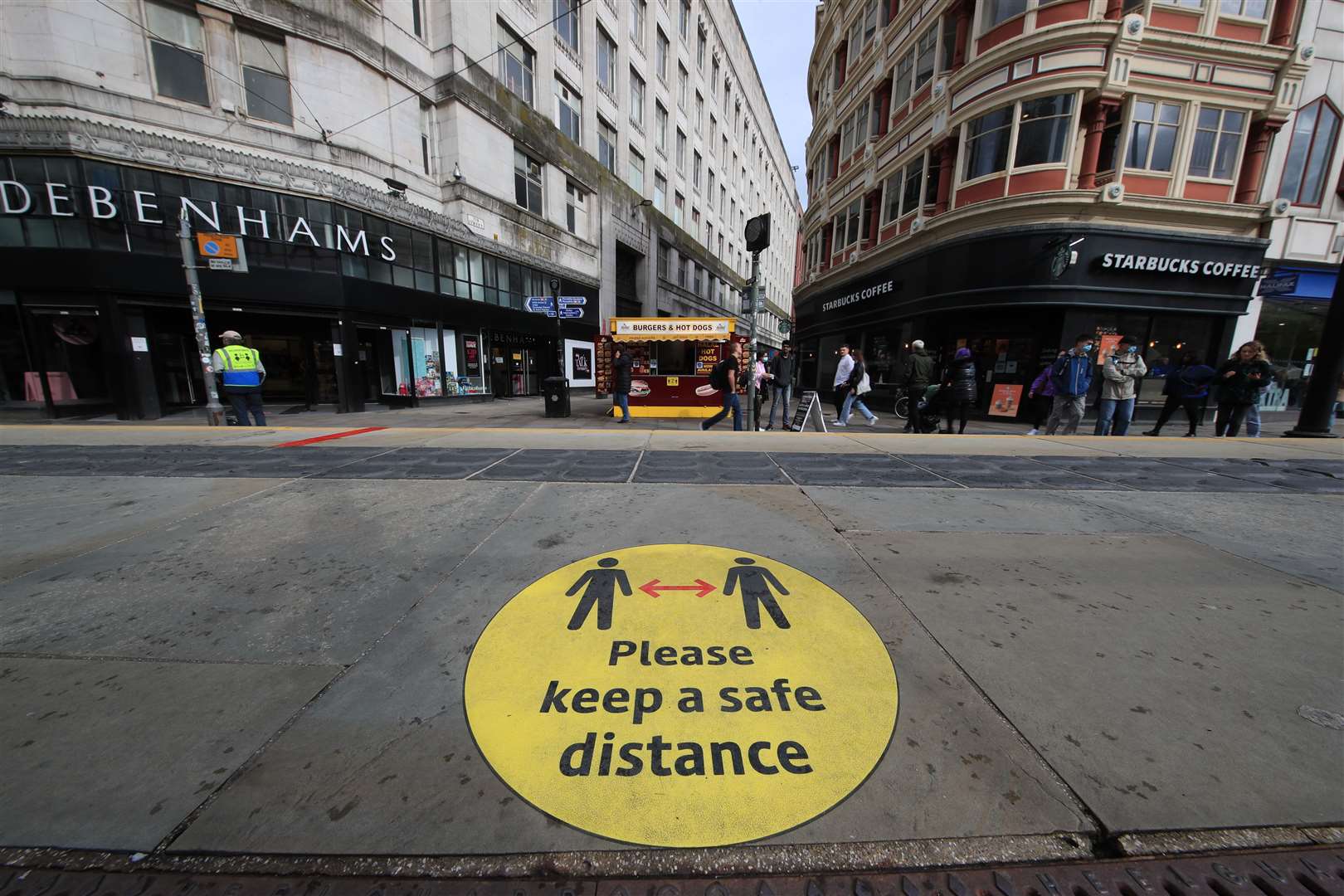 A social distancing guidance sign on the pavement in Manchester city centre (PA)