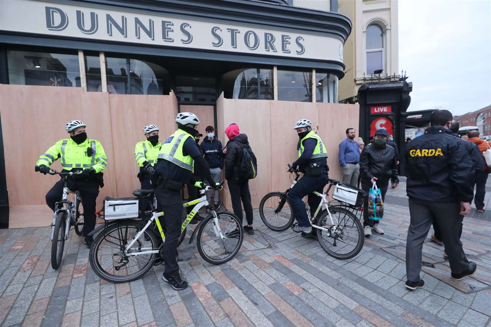 Gardai stop and search people before a demonstration against lockdown restrictions organised by the People’s Convention in Cork city centre (Niall Carson/PA)