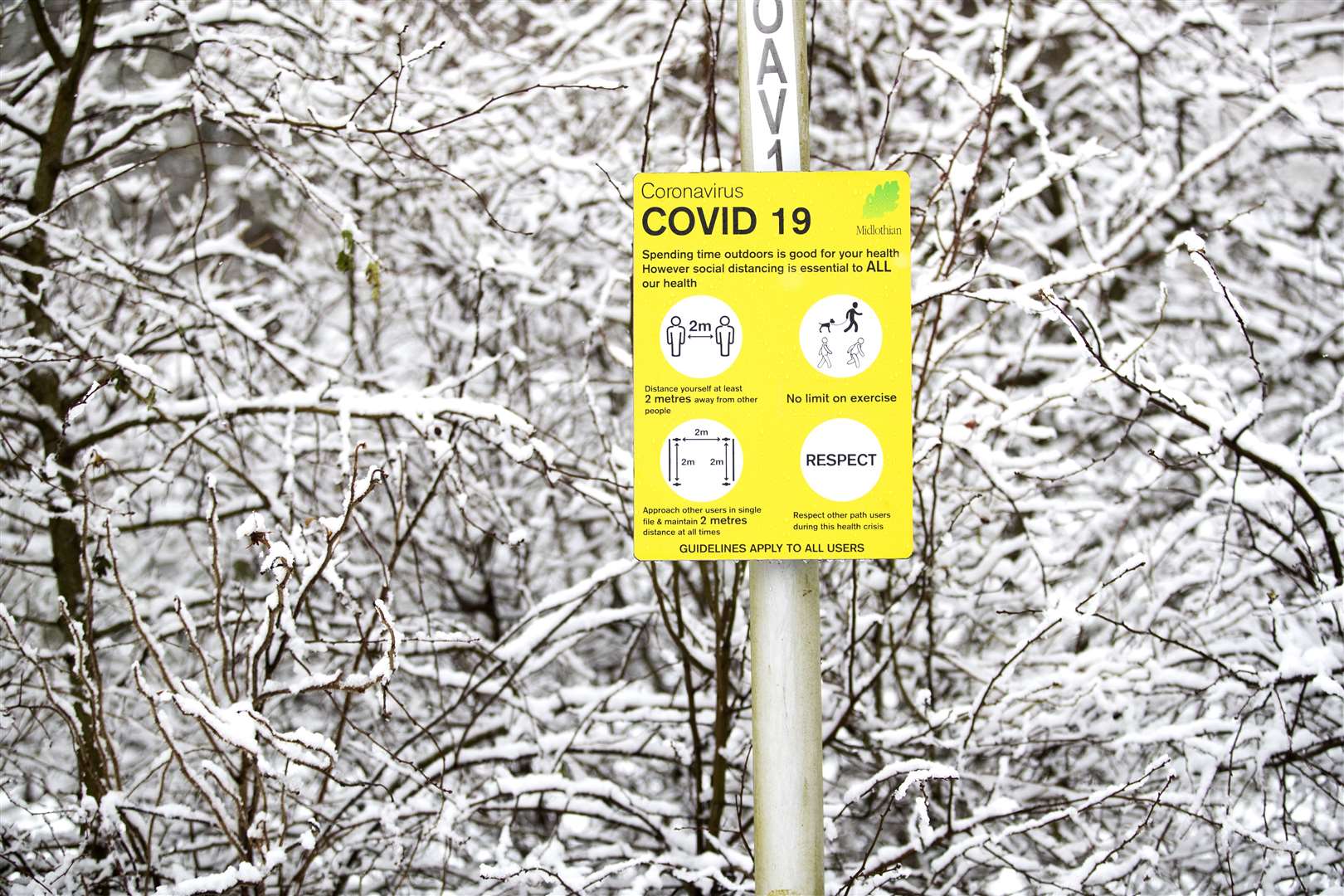 A coronavirus information sign surrounded by snow in Auchendinny, Midlothian (Jane Barlow/PA)