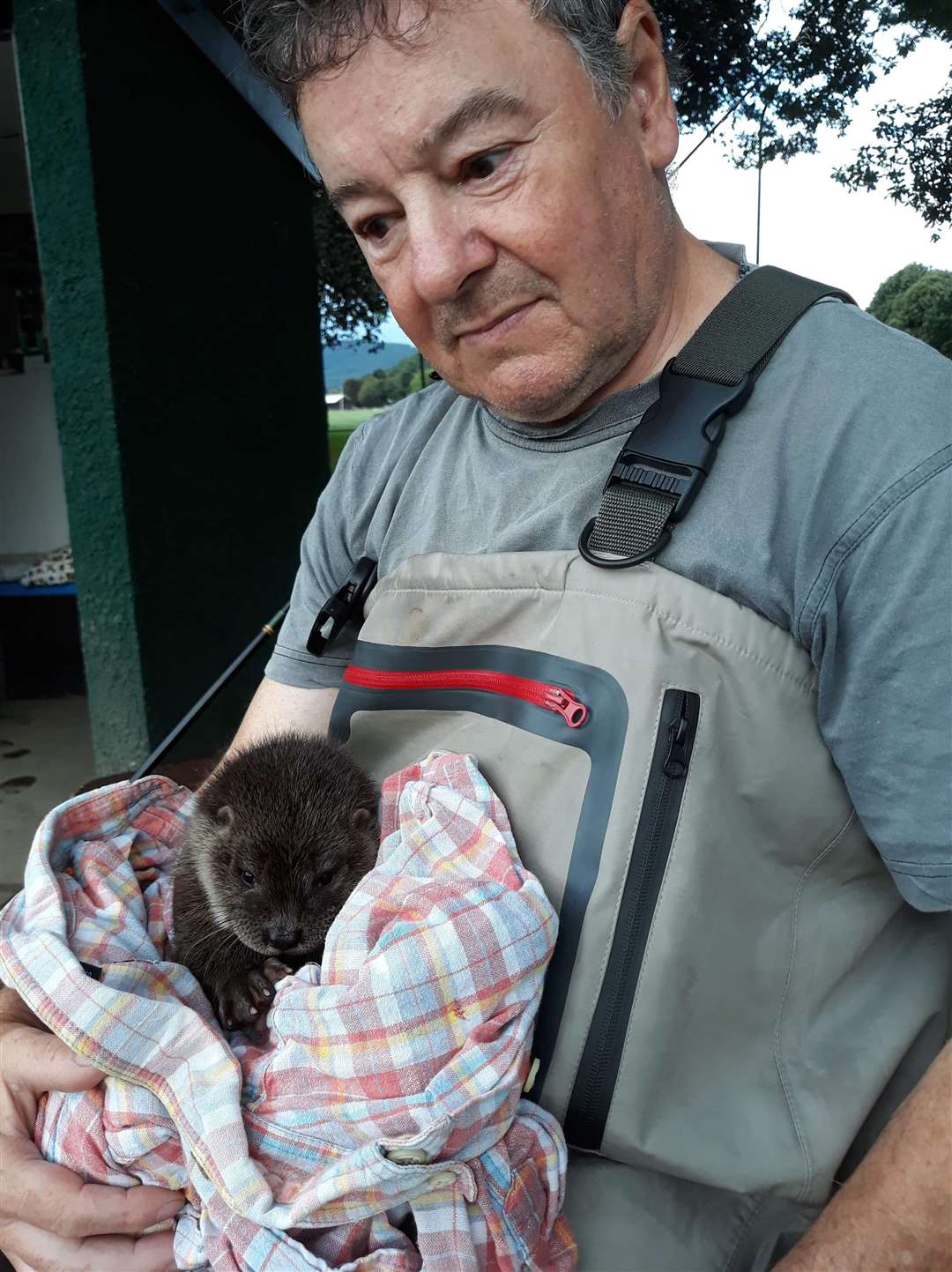 The baby otter with its rescuer James Buchanan.
