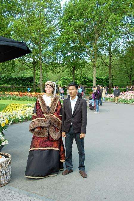 One of the staff in traditional dress, poses for yet another photograph with a tourist