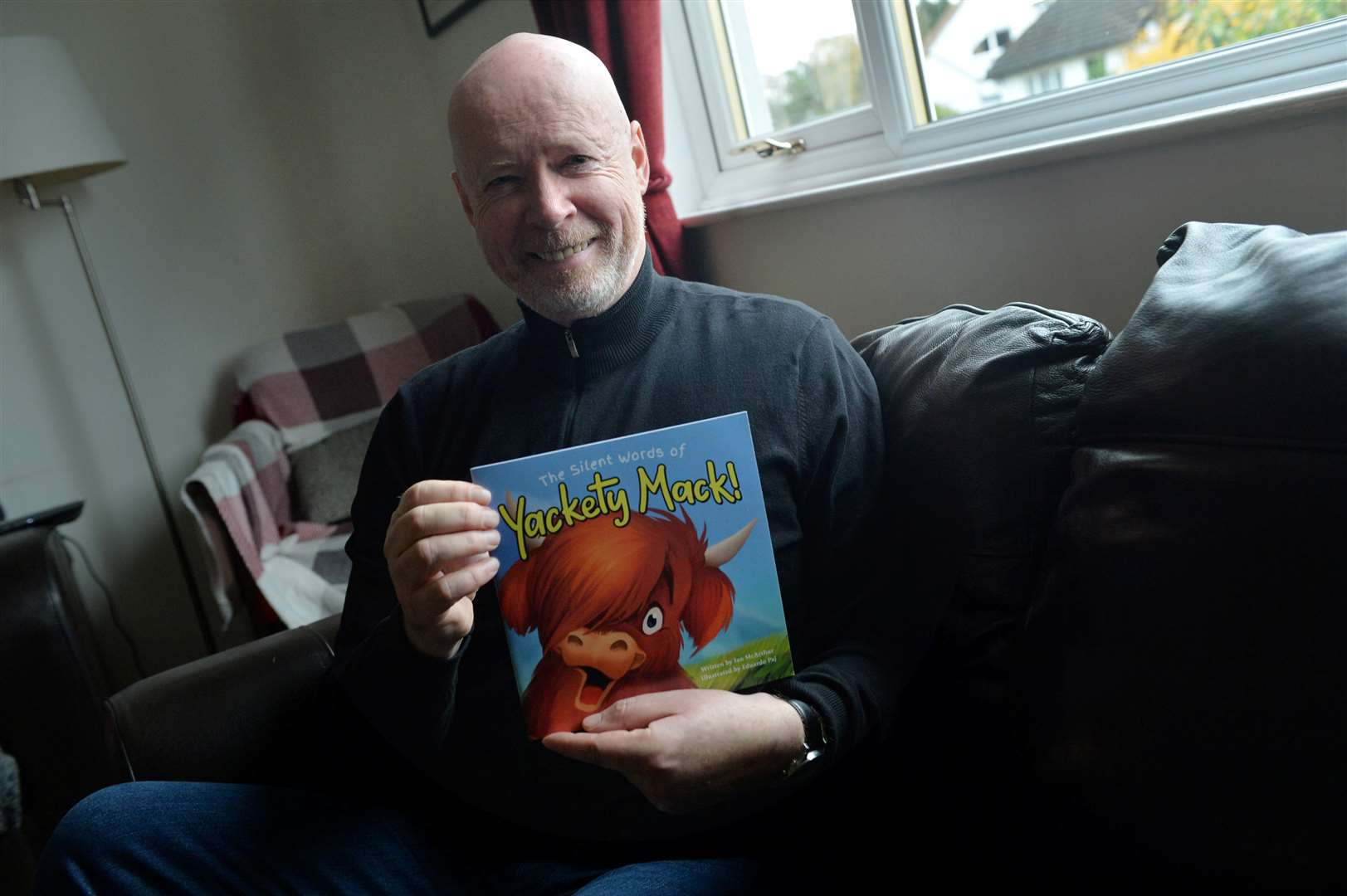 Teacher and author Ian McArthur with one of his children’s books. Picture: Callum Mackay