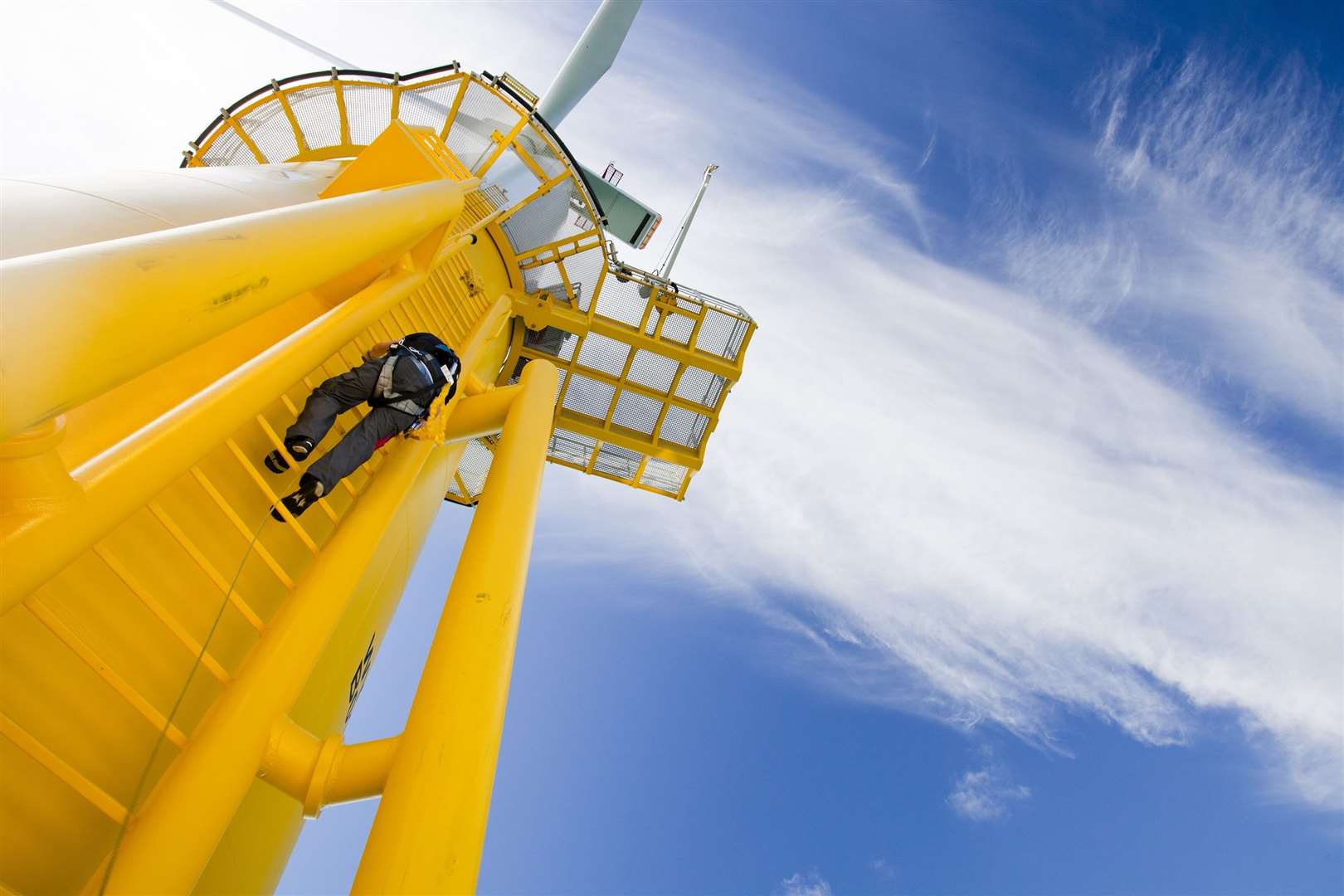 A worker climbs a turbine, at the Walney offshore wind farm which consists of 102, 3.6 MW turbines, giving a total capacity of the Walney project of 367.2 MW, enough to power 320,000 homes. The rotor diameter of the turbines is 107m for Walney 1 and 120 m for Walney 2. The wind farm is owned and constructed by Dong Energy. Cumbria, UK.