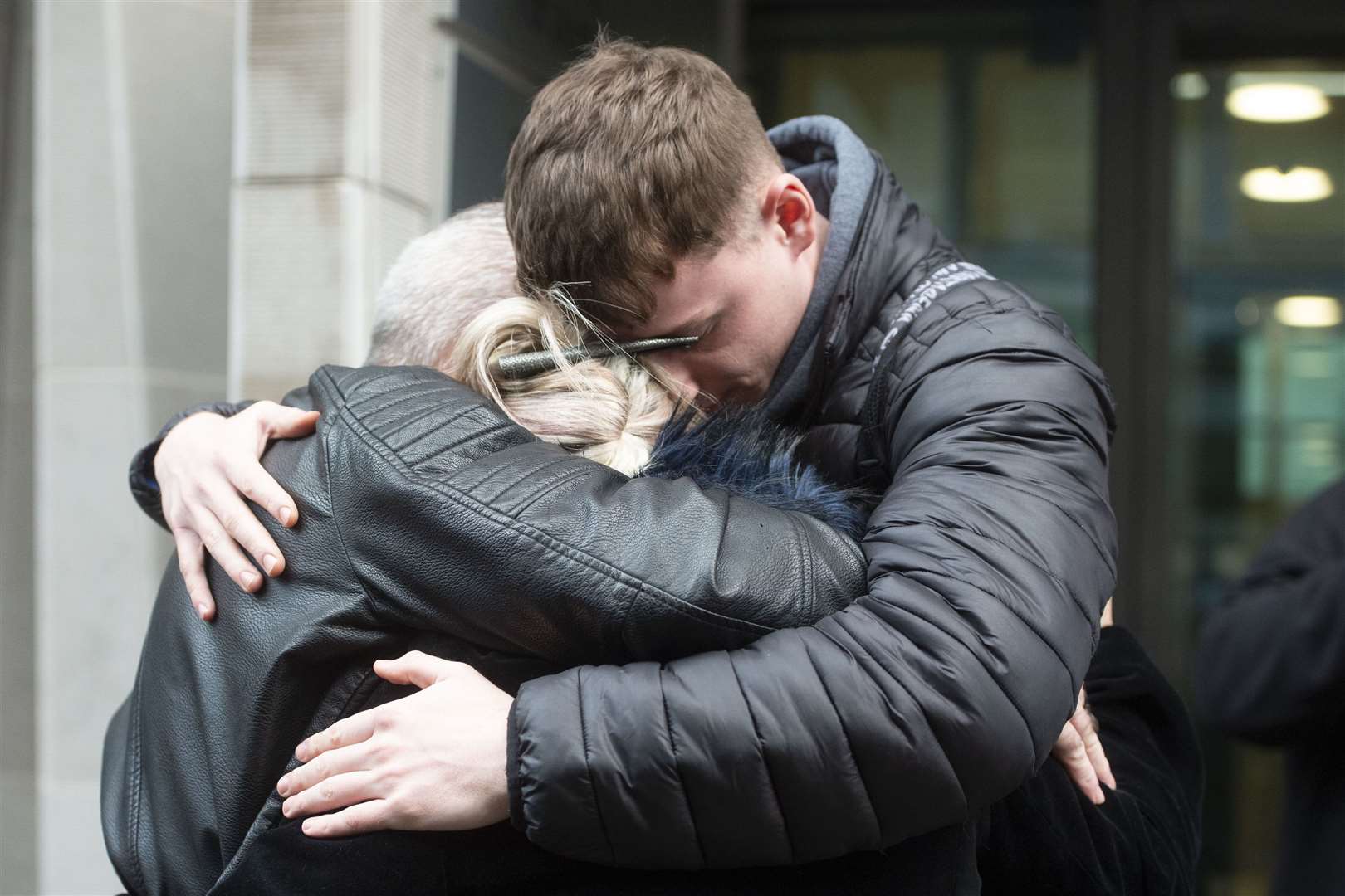 Charlotte Charles, Bruce Charles (left) and family friend Isaac Seiger hug outside the Ministry of Justice in London after meeting the director of public prosecutions. Anne Sacoolas has been charged with causing death by dangerous driving (David Mirzoeff/PA)