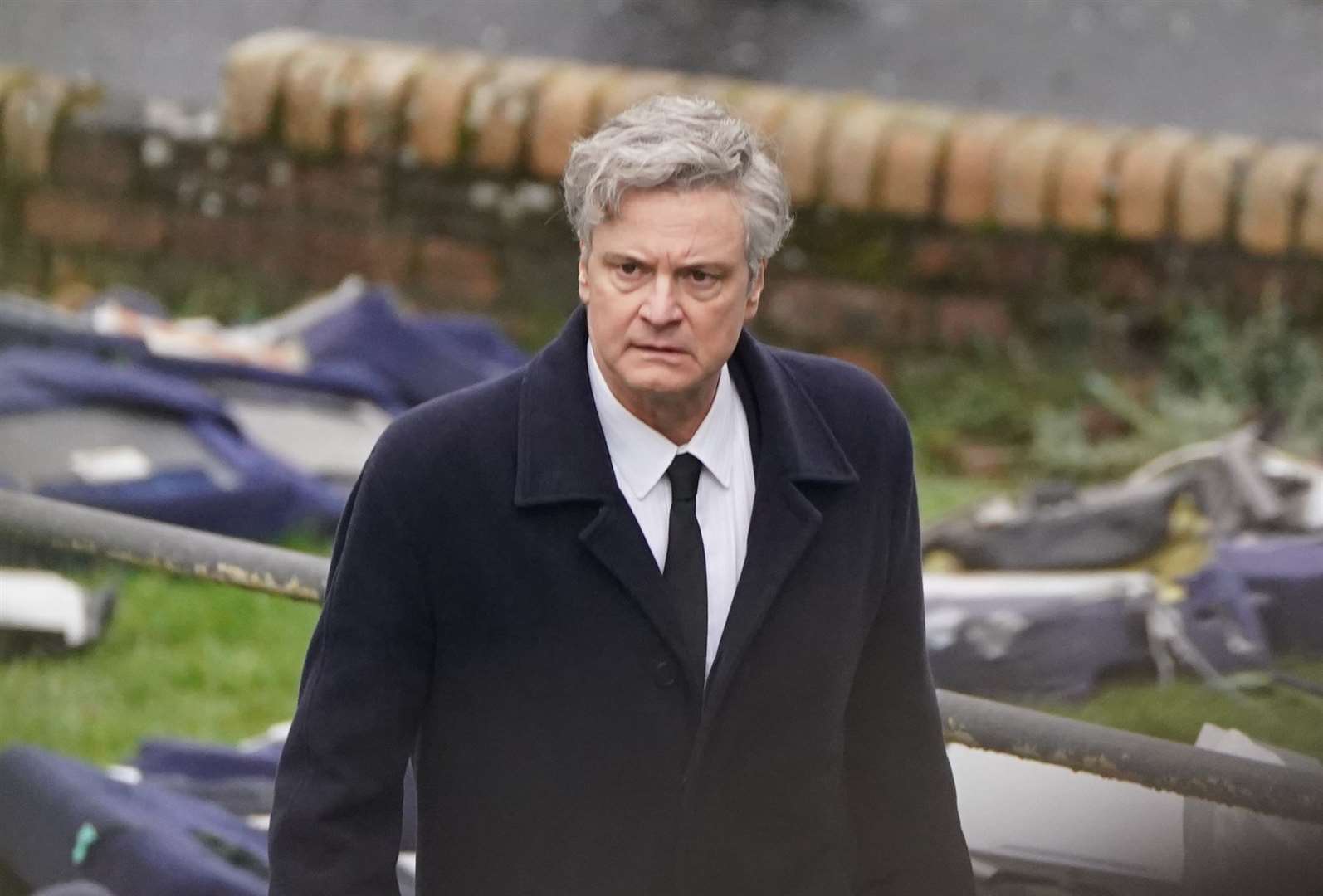 Colin Firth looks troubled as he walks through a scene recreating Lockerbie, following the events of the bombing (Andrew Milligan/PA)