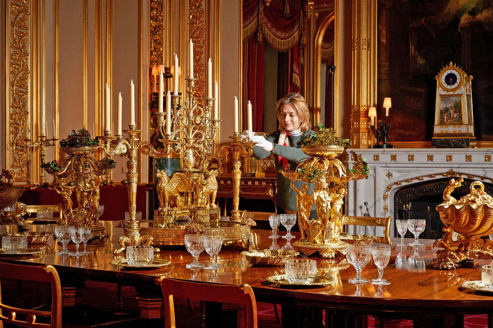 A curator puts the finishing touches on the display of the silver-gilt Grand Service in the State Dining Room (Royal Collection/Her Majesty Queen Elizabeth II 2020/PA)
