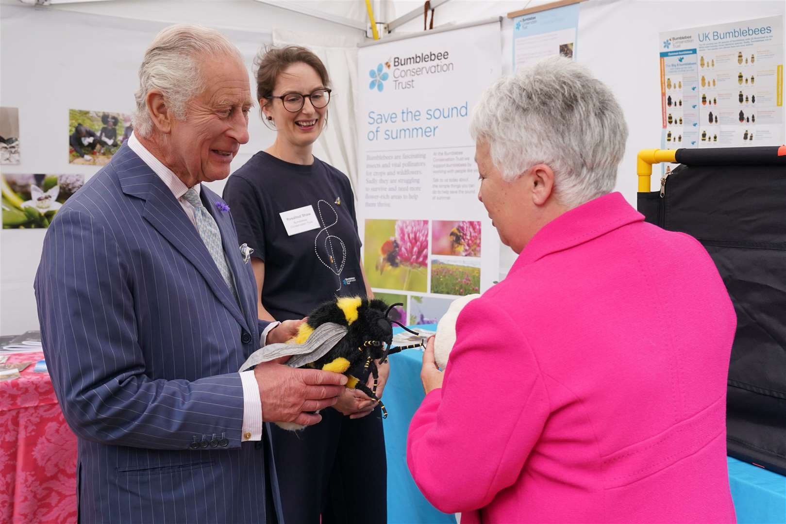 Charles is presented with a stuffed toy bumblebee by Gill Perkins, right, CEO of the Bumblebee Conservation Trust, and Rosalind Shaw, centre, project officer at the Bumblebee Conservation Trust (Jonathan Brady/PA)
