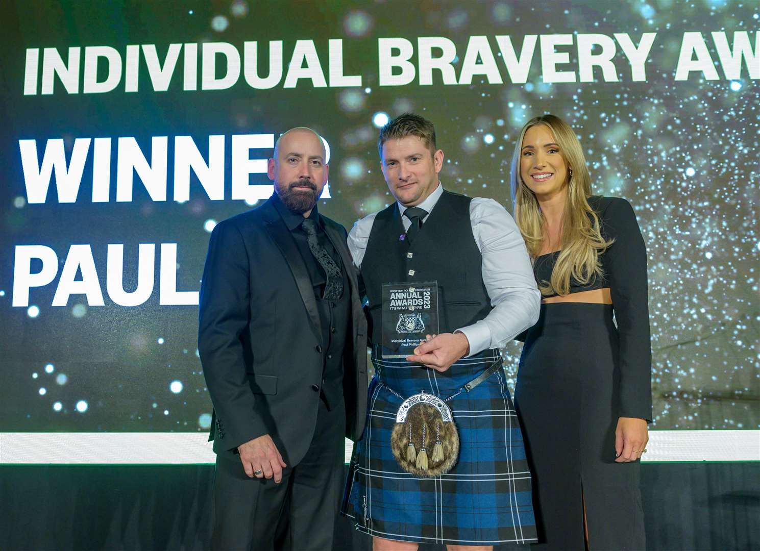 Paul Phillips (centre) is receives the Individual Bravery Award from David Kennedy, general secretary of the Scottish Police Federation, and event host Amy Irons. Picture: Sandy Young/scottishphotographer.com.