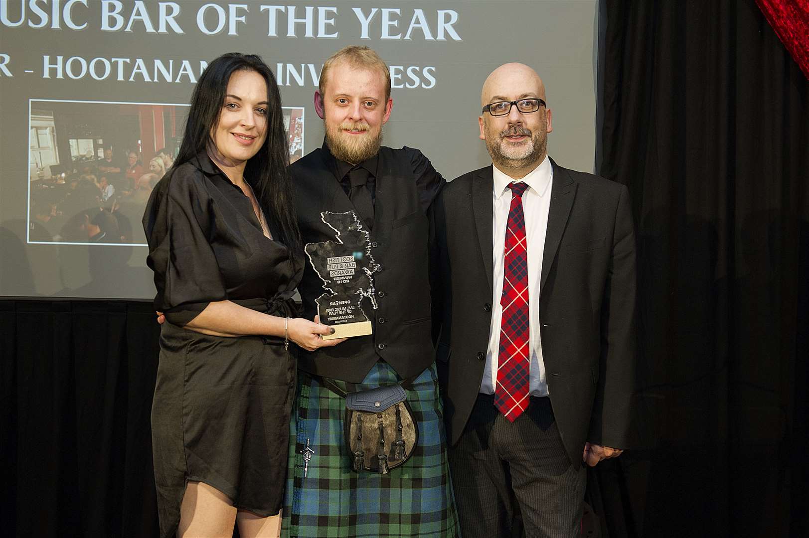 Brian D’Souza, of Open Ear (right), presents the award to Alister Mckay and Emma Wemyss.