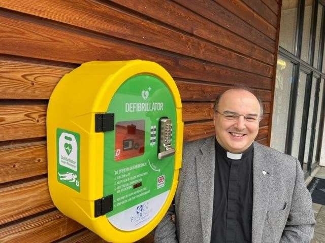 Fr. Domenico Zanré with the newly installed public defibrillator fitted to the wall outside St. Columba’s Church in Culloden.