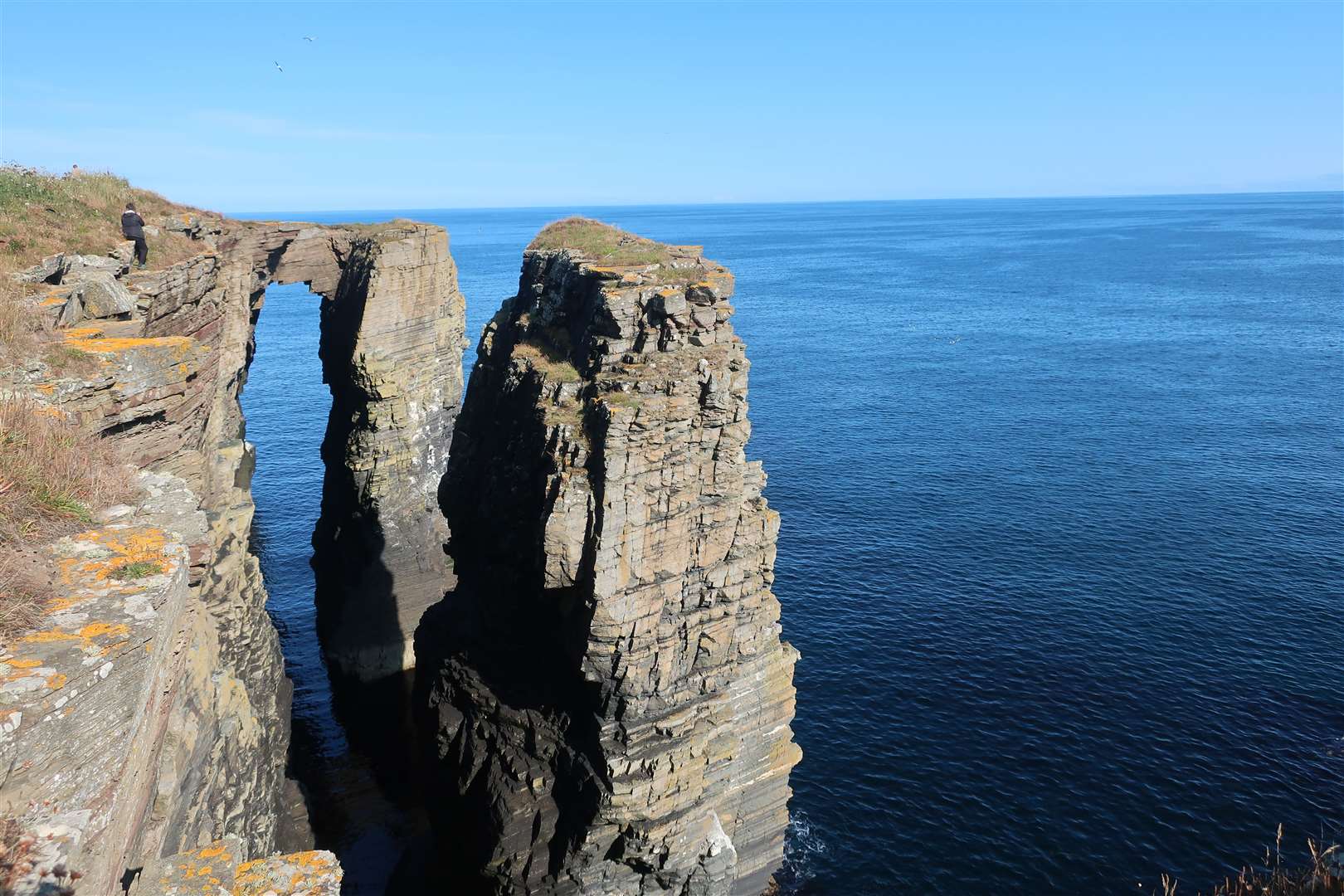 A dramatic arch and sea stack passed on the way south beyond the castle.