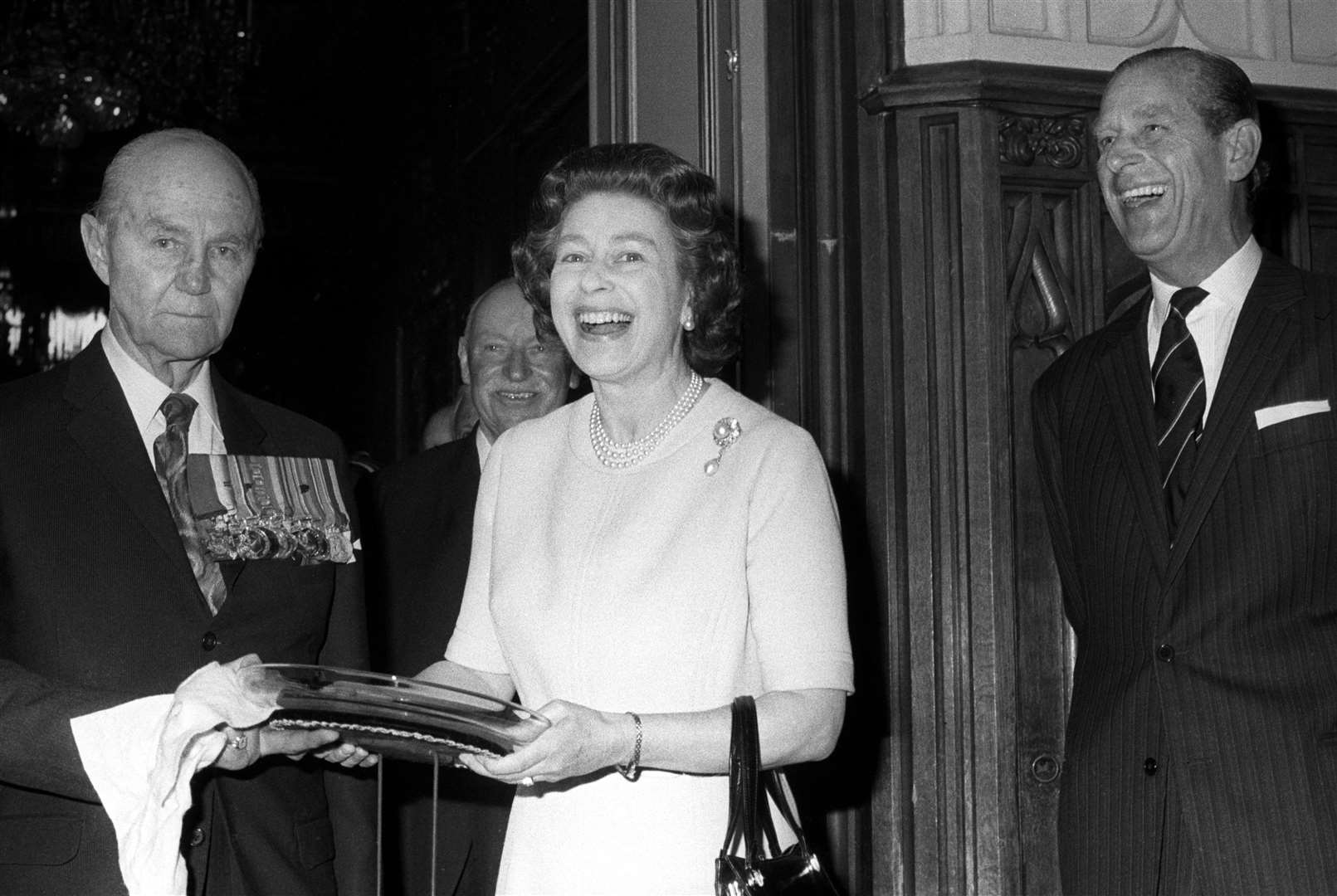 A delighted Queen receives a 50th birthday gift from the Victoria Cross and George Cross Association in 1976 (PA)