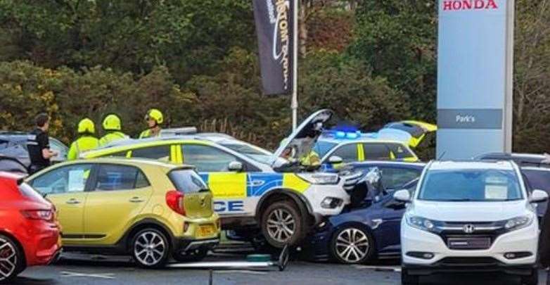 The police car collided with parked vehicles.