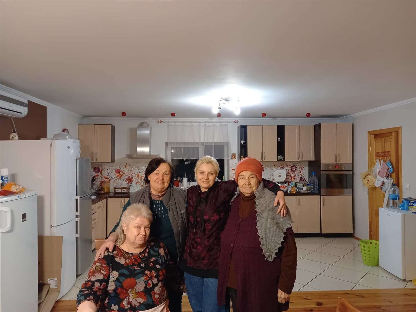 Irina Klimova (second left) is the house mum of the Renewal Childcare Centre in Ukraine, with recently arrived refugees including an 85-year-old (right).