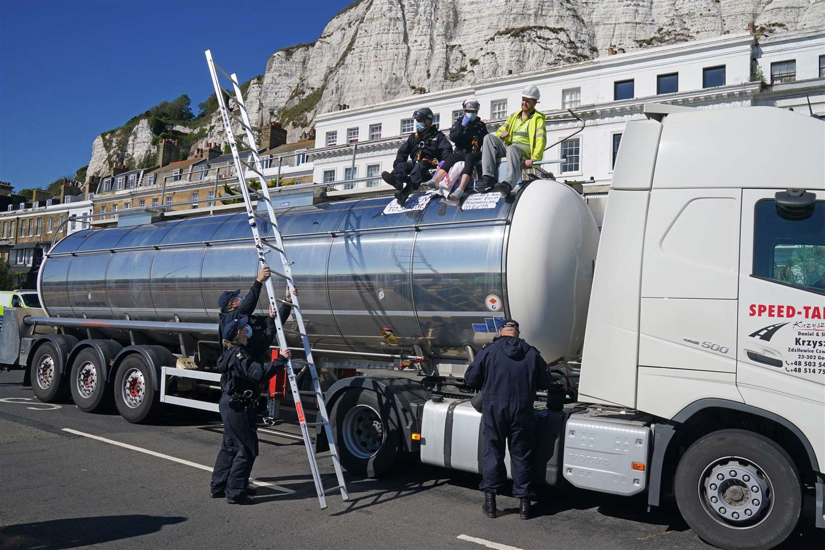 Police officers remove two protesters from the top of a tanker (Gareth Fuller/PA)