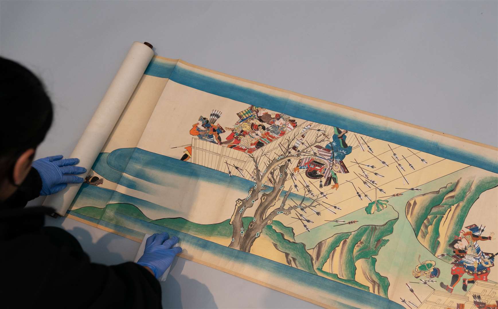 Collections digitisation assistant Ayesha Hussain unrolls one of three Japanese scrolls (Joe Giddens/PA)