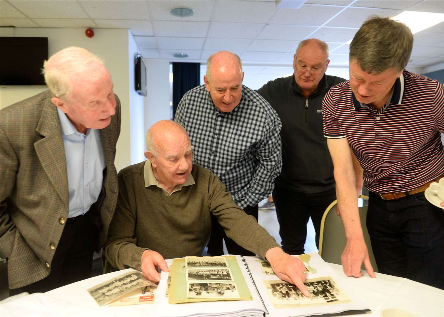 Former Thistle and Caley player Alex Grant, former Caley, Clach and Forres keeper Ian MacDonald, Peter Corbett who played for Caley, Clach and Thistle, Ewan MacDonald of Dingwall Thistle and Thistle legend David Milroy browse Ian's football memories book.