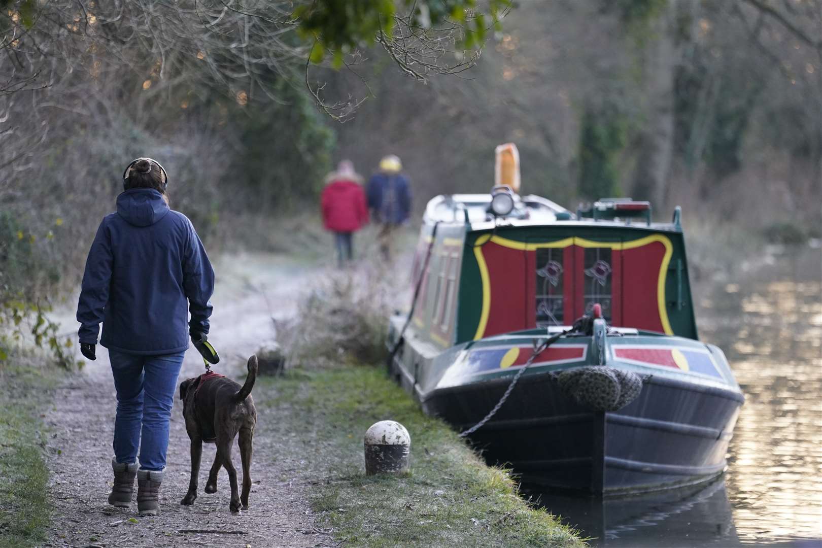 People make their way along the Basingstoke Canal near to Dogmersfield in Hampshire (Andrew Matthews/PA)