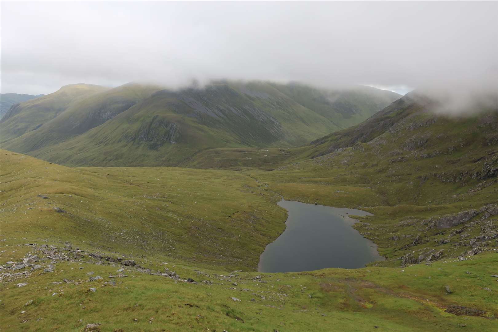 Lochan Gaineanhach in a hidden valley looking over to a cloud-shrouded Maoile Lunndaidh.