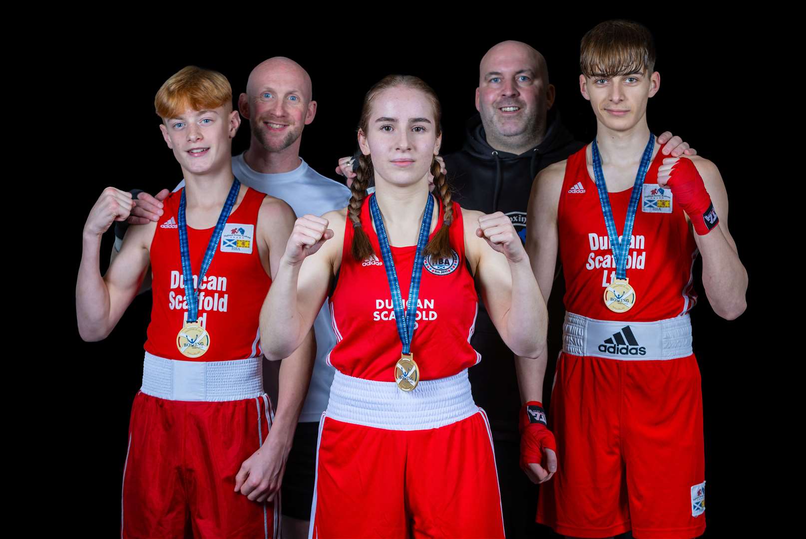 Rio Peden (48kg Champion), Isabella Fioretti (63kg Champion) and Josh Burnside (57kg Champion) with Highland Boxing Academy (HBA) coaches Barry Morrison and Liam Foy after a successful 2023 Development Championships.