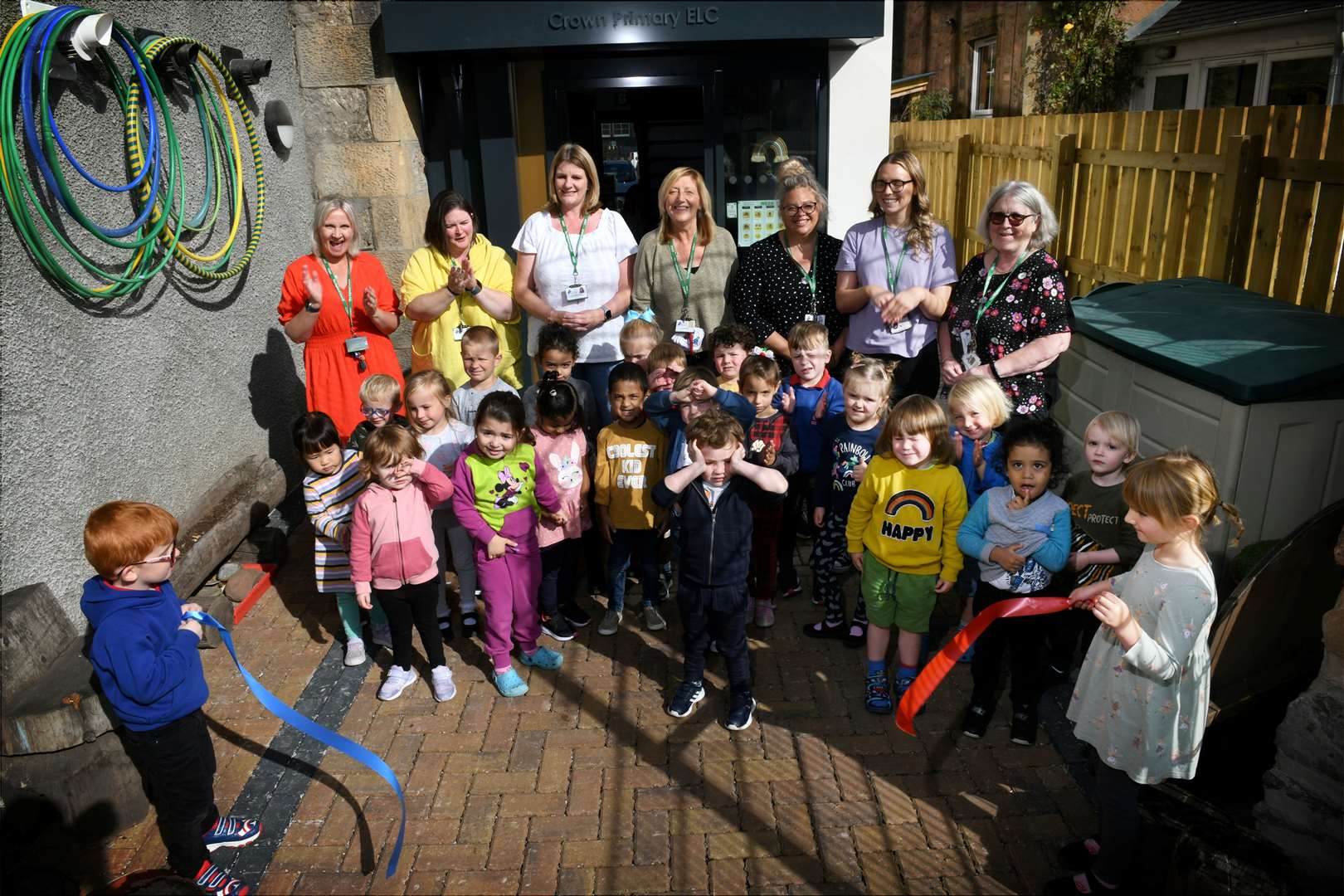 Children and staff at Crown Primary School's nursery watch as Albie Loynd and Eva Mackay break the ribbon to mark the opening of the new classrooms.