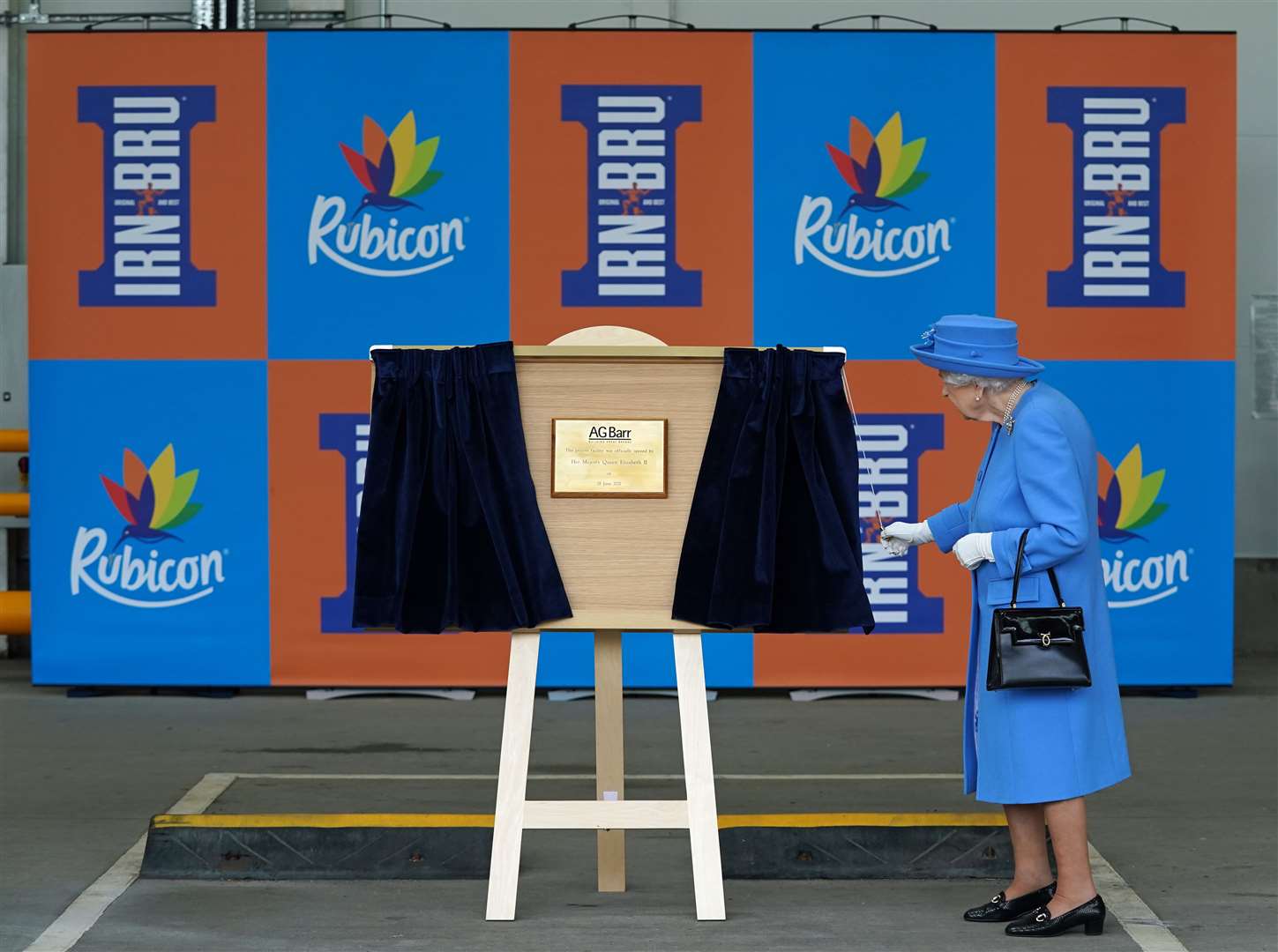 The Queen unveils a plaque during a visit to AG Barr’s factory in Cumbernauld, where the Irn-Bru drink is manufactured, as part of her traditional trip to Scotland for Holyrood Week in June (Andrew Milligan/PA)