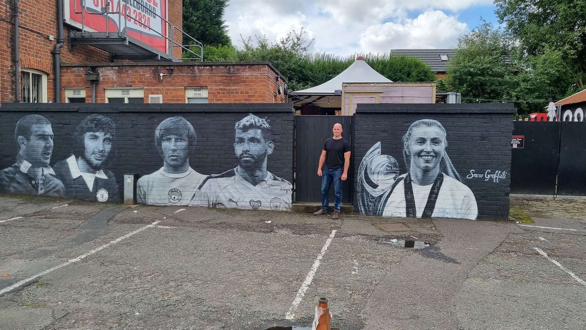Scott Wilcock with his football icons mural for a pub in Prestwich, Manchester (Scott Wilcock/PA)