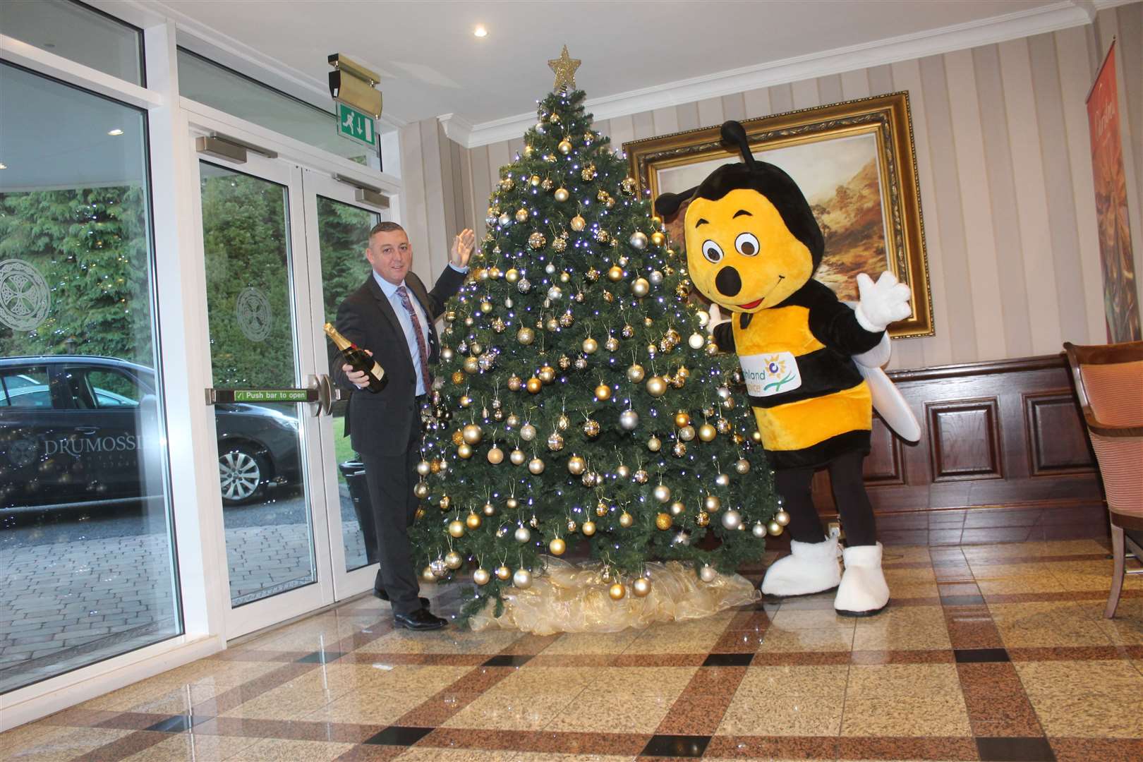 Kenny Mcmillan, general manager of the Drumossie Hotel, and Highland Hospice mascot Bobby the Bee.