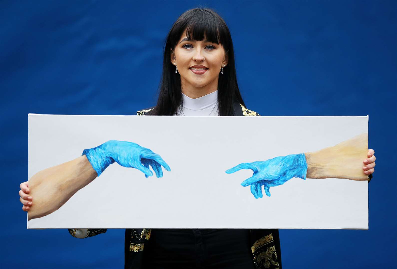 Chloe Slevin with her Covid-themed version of The Separation Of Adam, which she auctioned in aid of children’s ambulance service Bumbleance (Brian Lawless/PA)
