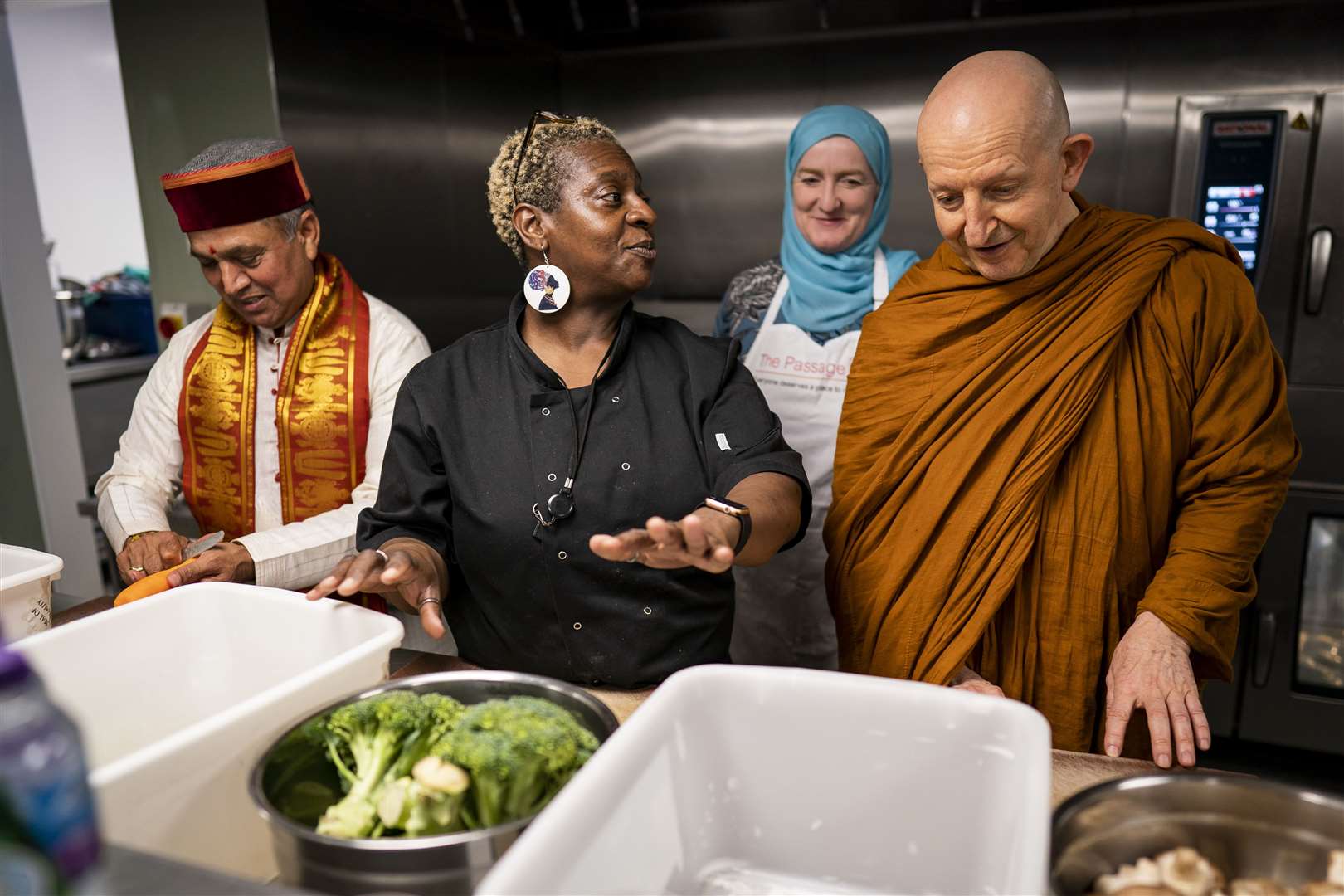 Krishan Kant Attri, Julie Siddiqi and Venerable Ajahn Amaro prepare food as they join other faith leaders at the Big Help Out event at the Passage in London (Aaron Chown/PA)