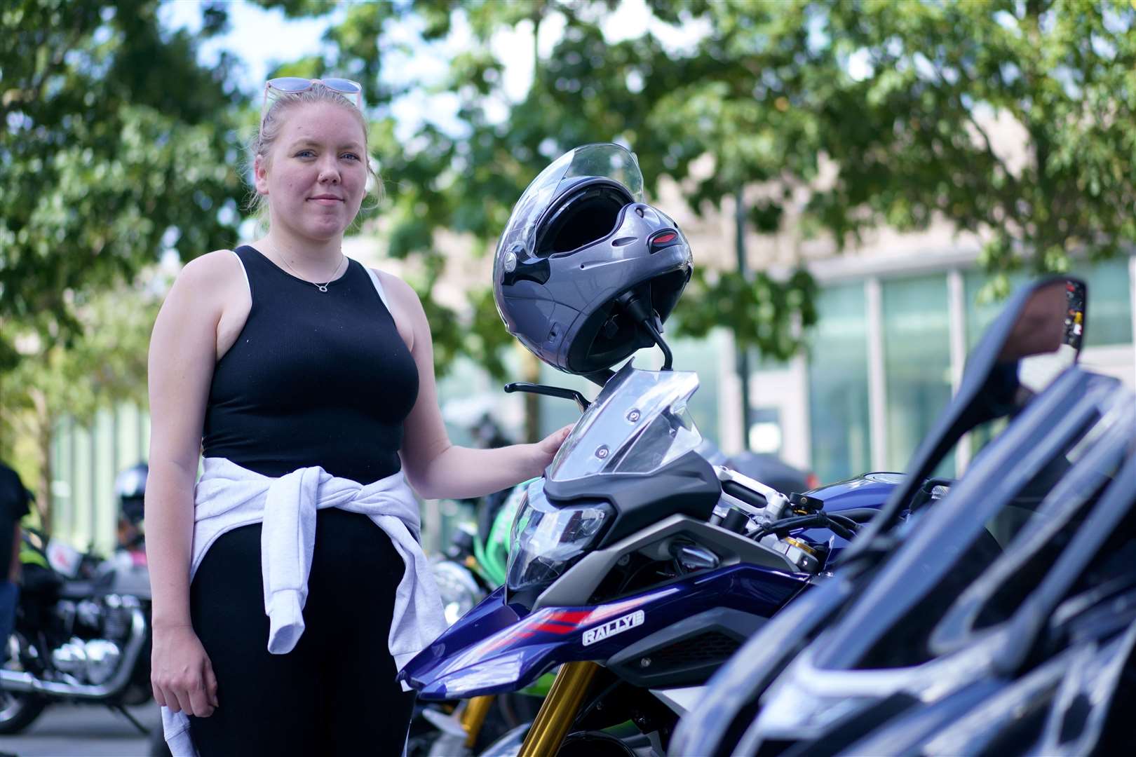 Harry’s friend, Chelsea Wilson, stands with motorbikes outside the US embassy (Victoria Jones/PA)