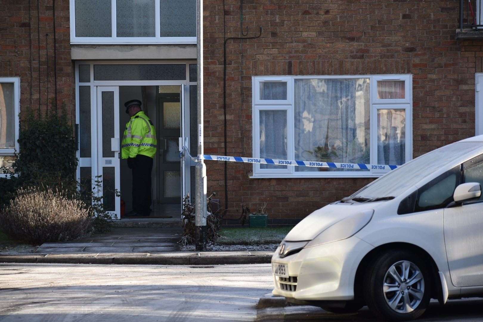 A police officer at the entrance to a block of flats in Petherton Court. (Matthew Cooper/PA)