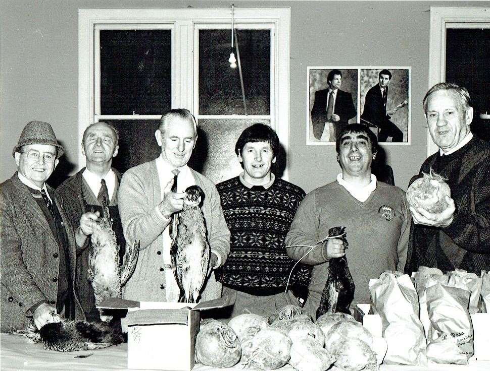 Denis Swanson (second from left) at an art sale in Inverness to benefit club funds.