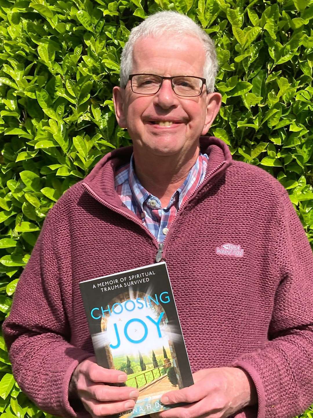 John with a hard copy of his book, Choosing Joy.