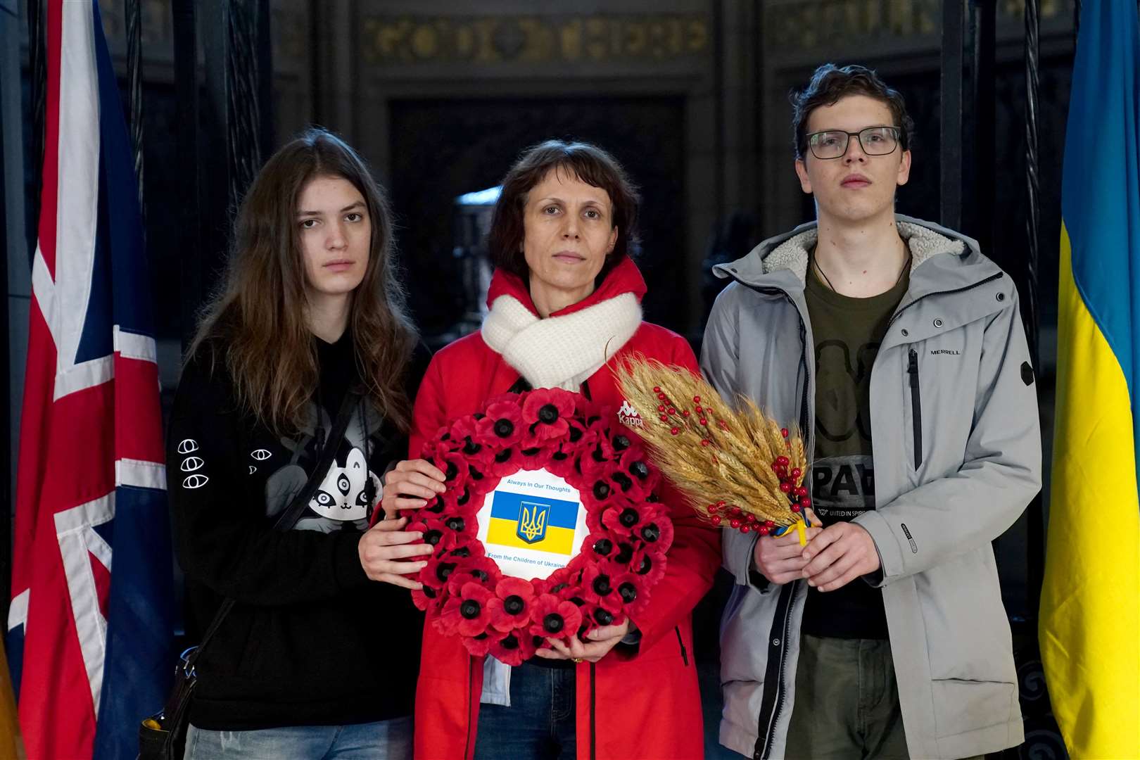 Oksana Rybalchenko, centre, with her daughter Kateryna, left, and son Denys before a service to mark the second anniversary at the Scottish National War Memoria (Jane Barlow/PA)