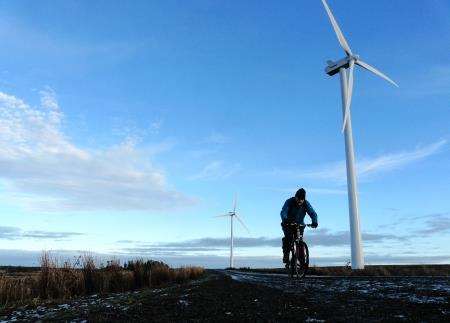 Alan cycling between the turbines on the Camster Wind Farm track.