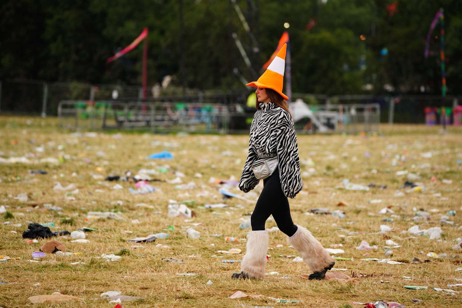 A festival-goer walks among discarded rubbish (Ben Birchall/PA)
