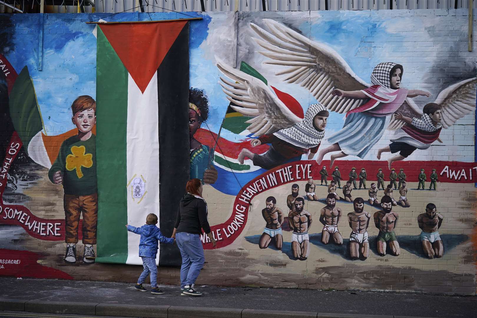 People at the unveiling of the International Wall in Belfast after it was transformed into a Gaza mural (Niall Carson/PA)