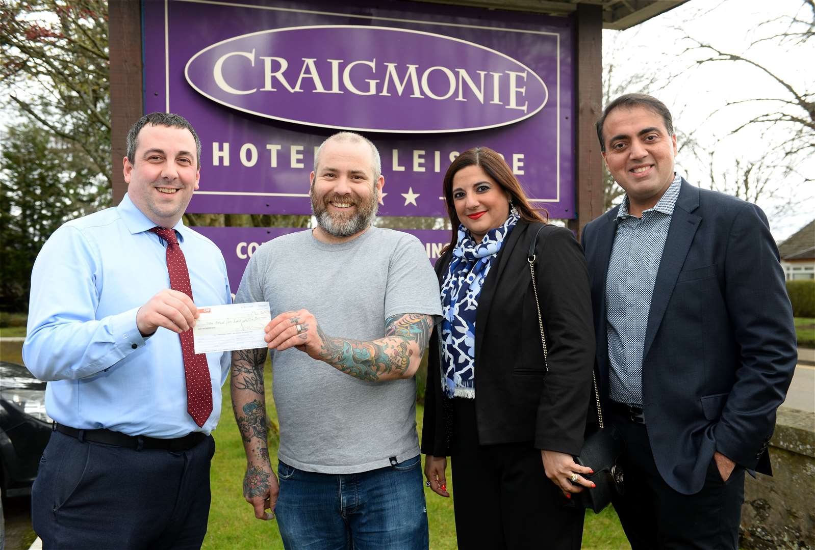 Kris Douglas (second left) receives the donation from general manager Niall MacLennan and owners Pia and Kishore Buxani. Picture: Gary Anthony. Image No.043572