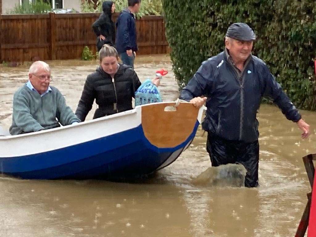 Simon O’Brien (right) using his homemade boat to rescue elderly residents from their home in Suffolk (Mary Scott/PA)