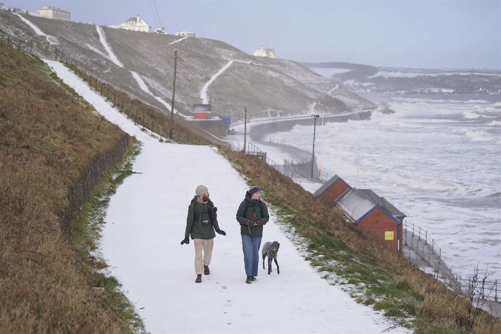 People walk along a snow-covered path in Whitby, North Yorkshire (Danny Lawson/PA)
