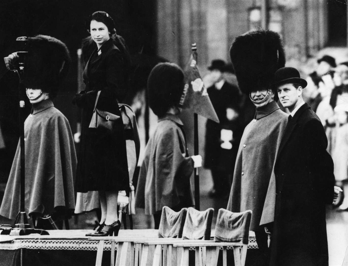 The new Queen in black mourning dress – with the Duke of Edinburgh in a bowler hat (right) – inspects Grenadier Guardsmen at Windsor Castle in April 1952 – the first ceremonial parade of her reign (PA)