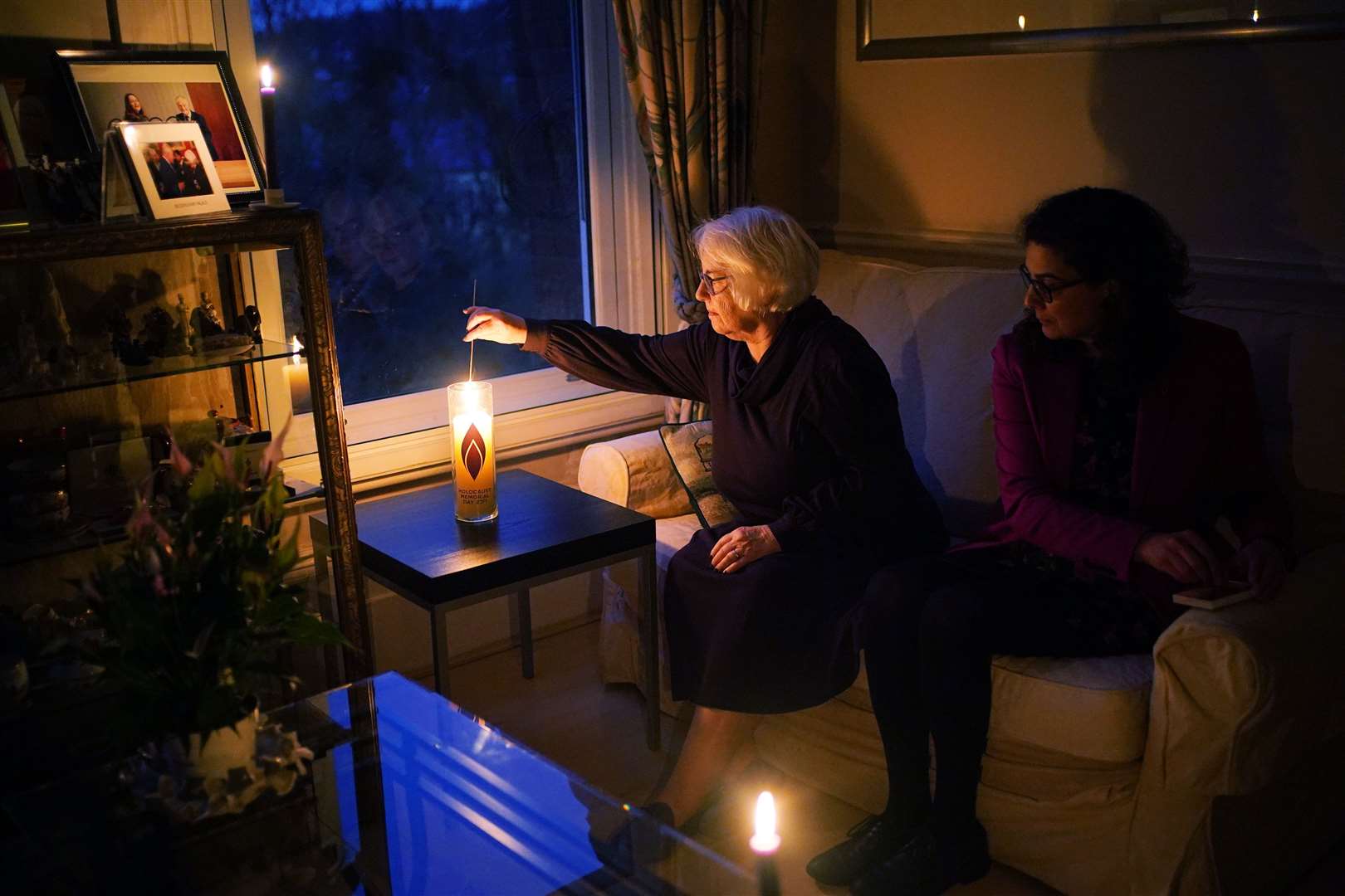 Holocaust survivor Joan Salter lights a memorial candle at her home in north London (Yui Mok/PA)