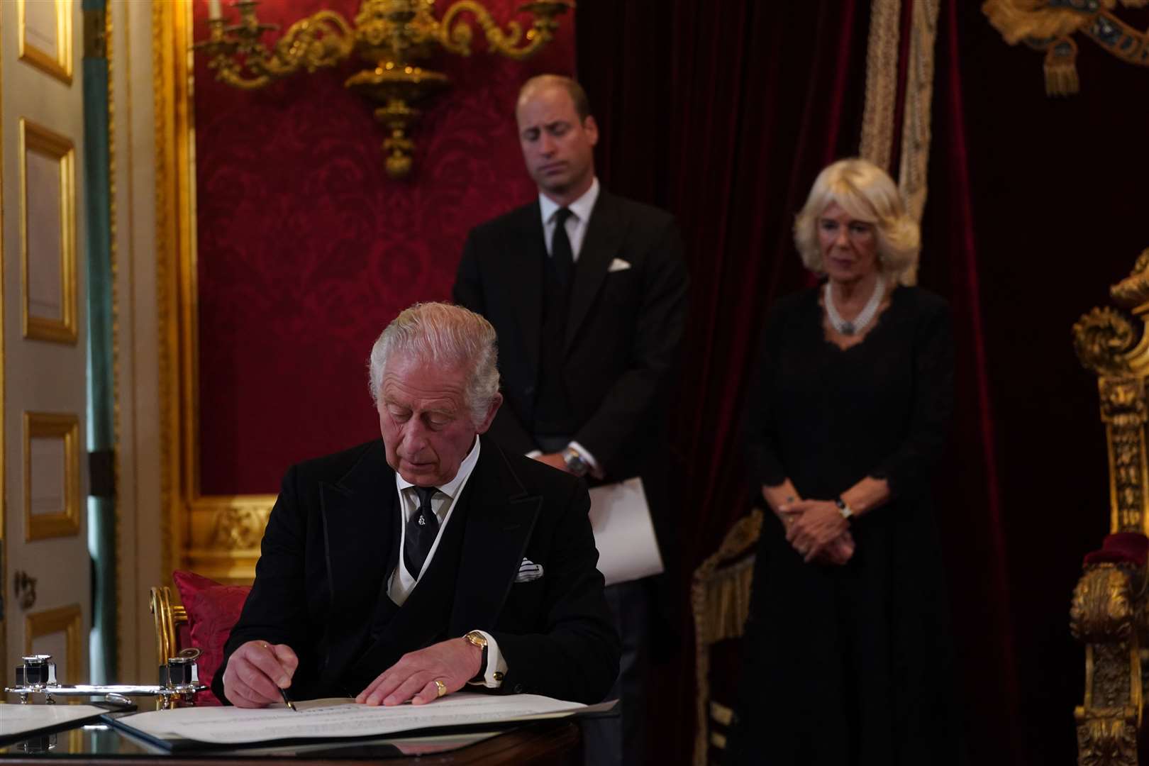 William and the Queen watch as King Charles III signs an oath to uphold the security of the Church in Scotland during the Accession Council (Victoria Jones/PA)